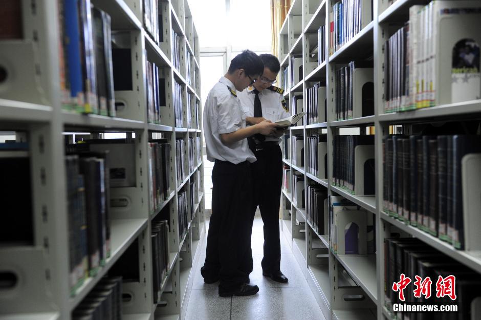 5月8日，武漢輕工大學保安吳濤與江力在圖書館交流學習。中新社發(fā) 張暢 攝