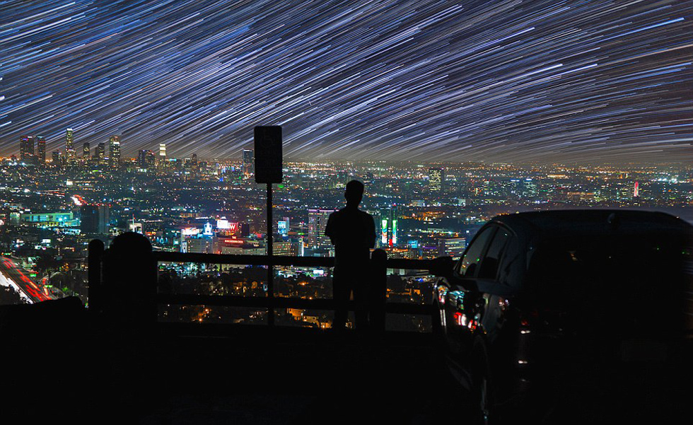 照片中，一名男子看著流星和隕星劃過天空。（網(wǎng)頁截圖）