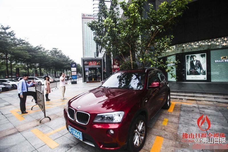 一輛停在停車位上的寶馬轎車，被墜落的樹枝砸中，樹枝徑直插入車內(nèi)，現(xiàn)場引發(fā)不少市民圍觀拍照。