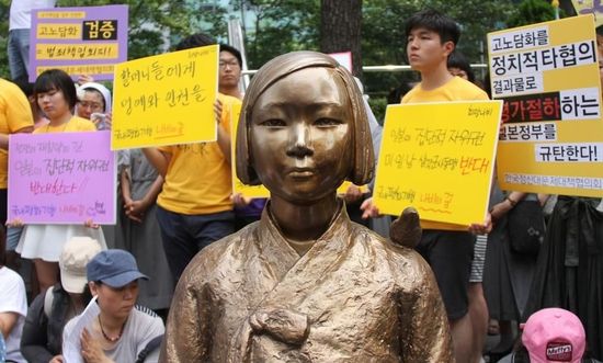 7月2日，在韓國(guó)首爾的日本駐韓國(guó)大使館前，民眾在慰安婦少女像旁手持標(biāo)語參加抗議活動(dòng)。