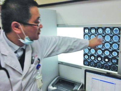 醫(yī)生在查看男孩的腦部CT片。薛馬義 攝