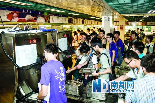 昨日，華南理工大學(xué)一食堂內(nèi)，學(xué)生們正在使用新安裝的自動(dòng)打飯機(jī)打飯。中新社發(fā)
