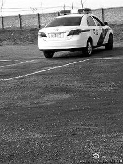 一輛車牌號(hào) 為“ 陜DD173”的制式警車停在一個(gè)劃著白線的場(chǎng)地上，車身標(biāo)有“司法”字樣