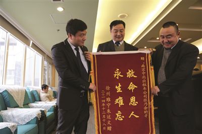 張乃余(中)和兩位救人的同伴一塊領(lǐng)獎。