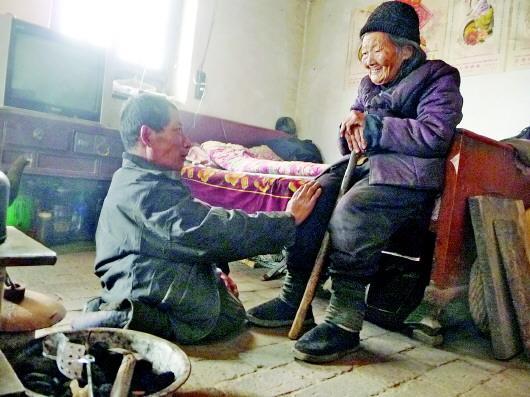 52歲的劉蘭山每天靠爬行照顧90歲的老母親。孫國祥 攝