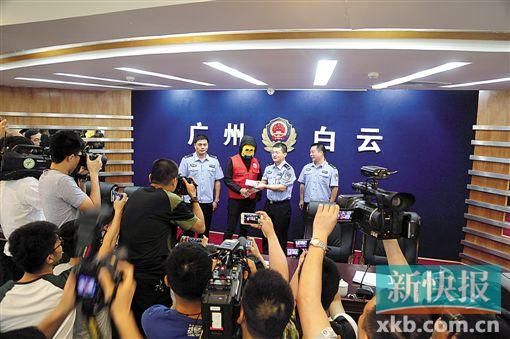 因舉報涉毒案件線索而獲獎的“快遞小哥”戴著面具領取獎金。