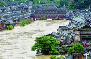7月16日,沱江兩邊的商鋪和遠(yuǎn)處的虹橋仍淹沒在洪水中。 新華社發(fā)