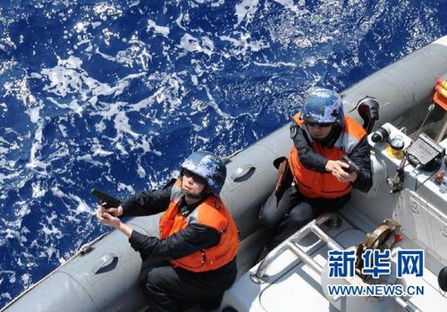 　3月28日，十余名臨檢拿捕隊員乘小艇駛至模擬可疑商船下方水面。