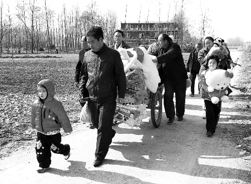 姐（左一）弟（右一護(hù)士懷中男嬰）返鄉(xiāng)，愛心捐贈(zèng)滿滿一架子車。
