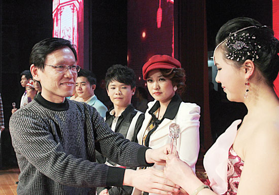 2013年2月1日，《對9當(dāng)歌》總決賽在鄭州開唱。圖為東方今報(bào)副社長胡楊為選手頒獎(jiǎng)