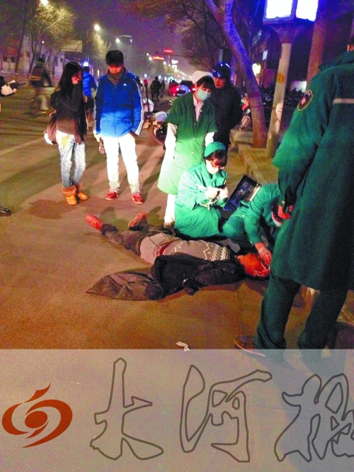 醉漢躺在地上，醫(yī)護(hù)人員對(duì)其進(jìn)行檢查。